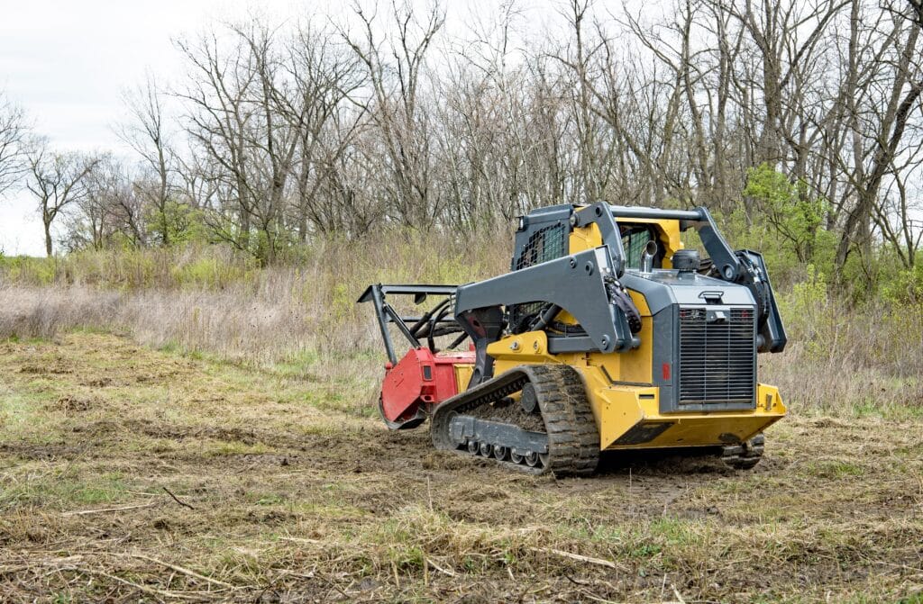 rear,view,of,forestry,mulcher,actively,mulching,weeds,from,field