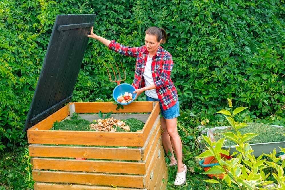 food,waste,in,a,compost,bin.,a,woman,in,a